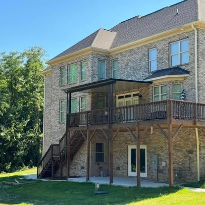 a large brick house with a large deck and stairs