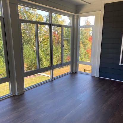 an empty room with a lot of windows and a wooden floor