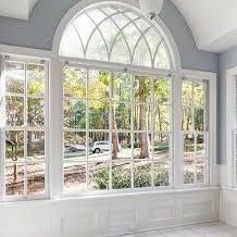 a room with a lot of windows and a view of a forest