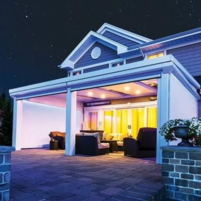 a house is lit up at night with a patio in front of it