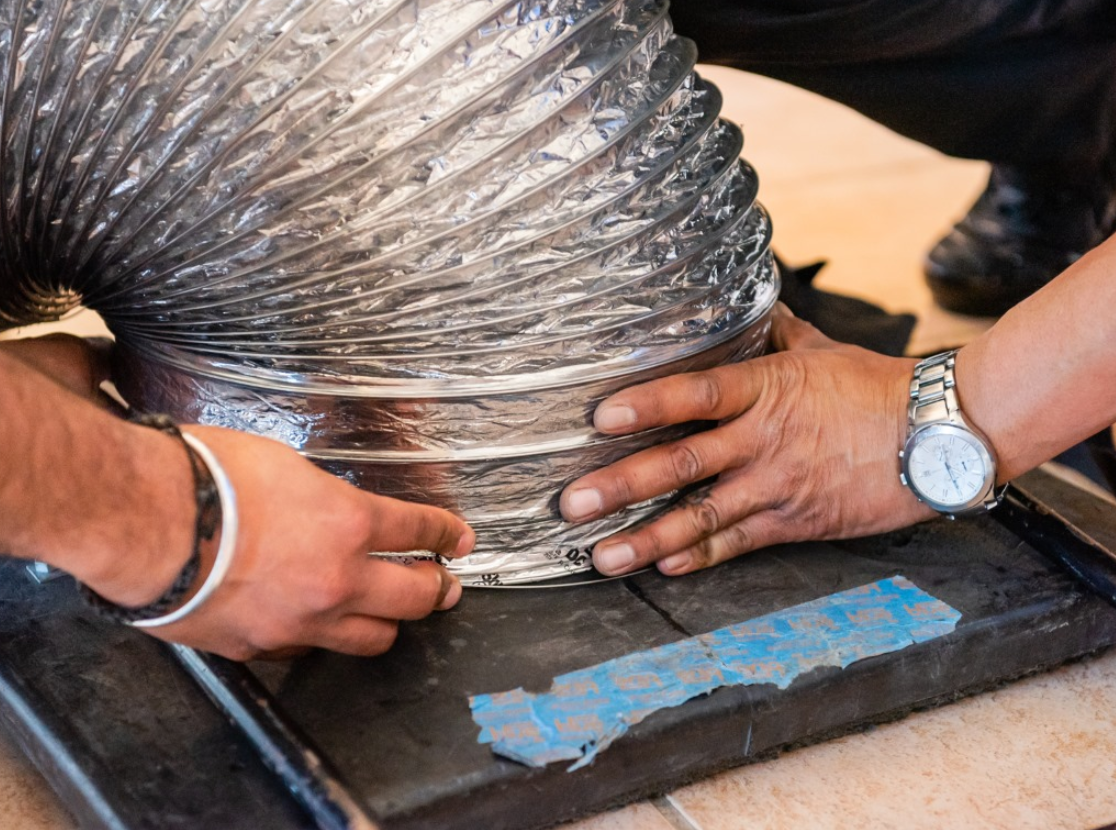 a man is measuring a duct hose.
