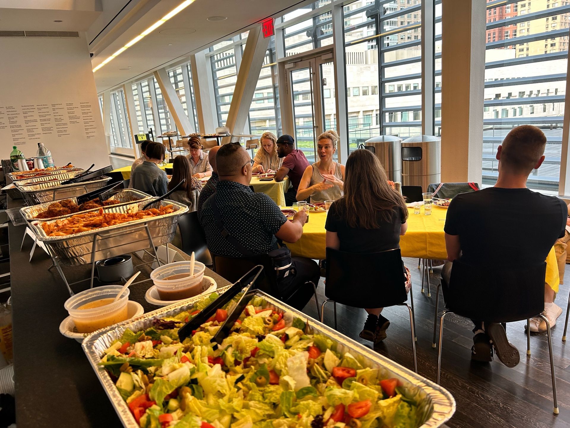 A group of people are sitting at tables with trays of food.
