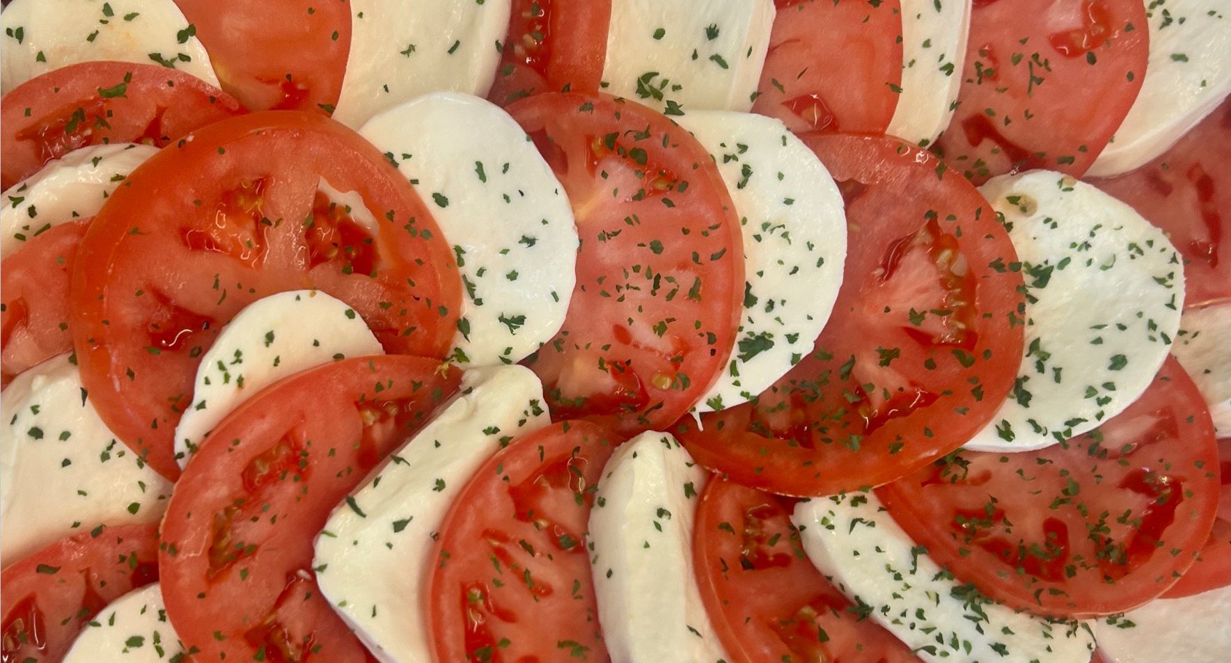 A close up of tomatoes and mozzarella slices on a plate.