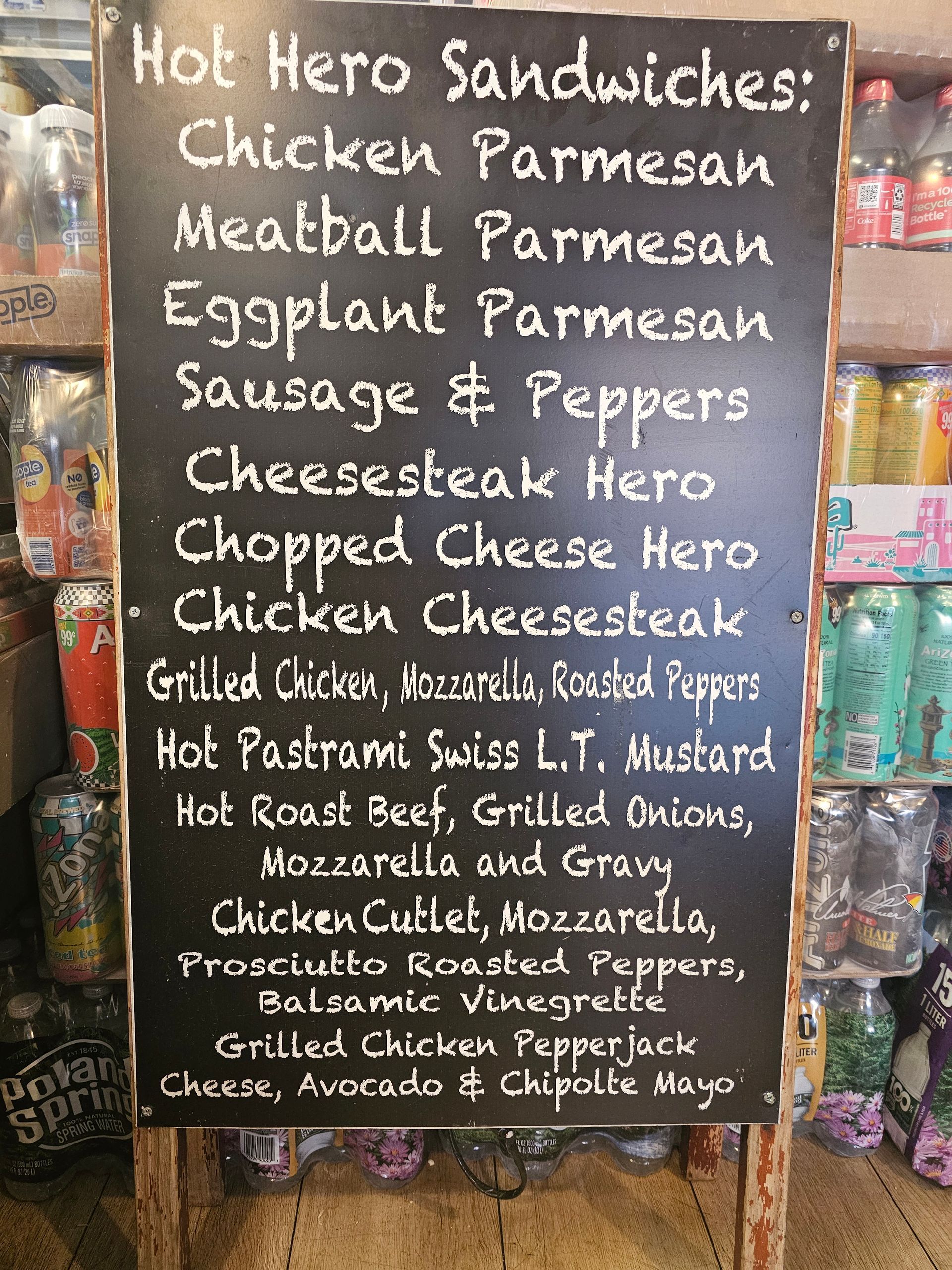 A blackboard with a list of hot hero sandwiches.