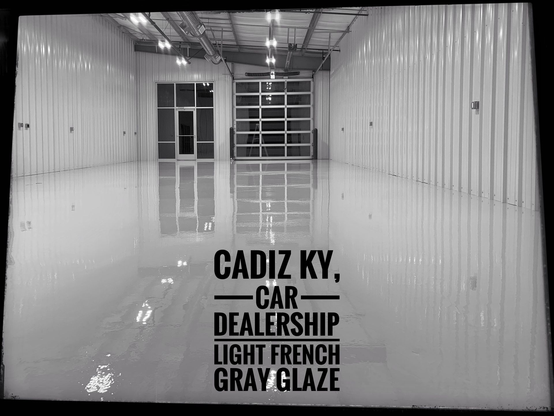 Empty white showroom with glass doors and floor text reading “Cadiz KY Car Dealership Light French Gray Glaze”