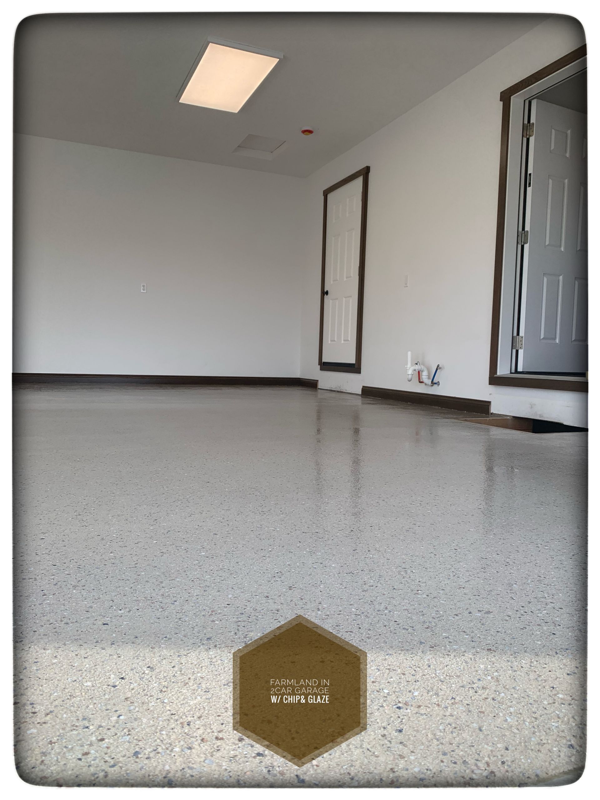 Empty unfurnished room with gray speckled floor, white walls, and two doors, viewed from the floor level