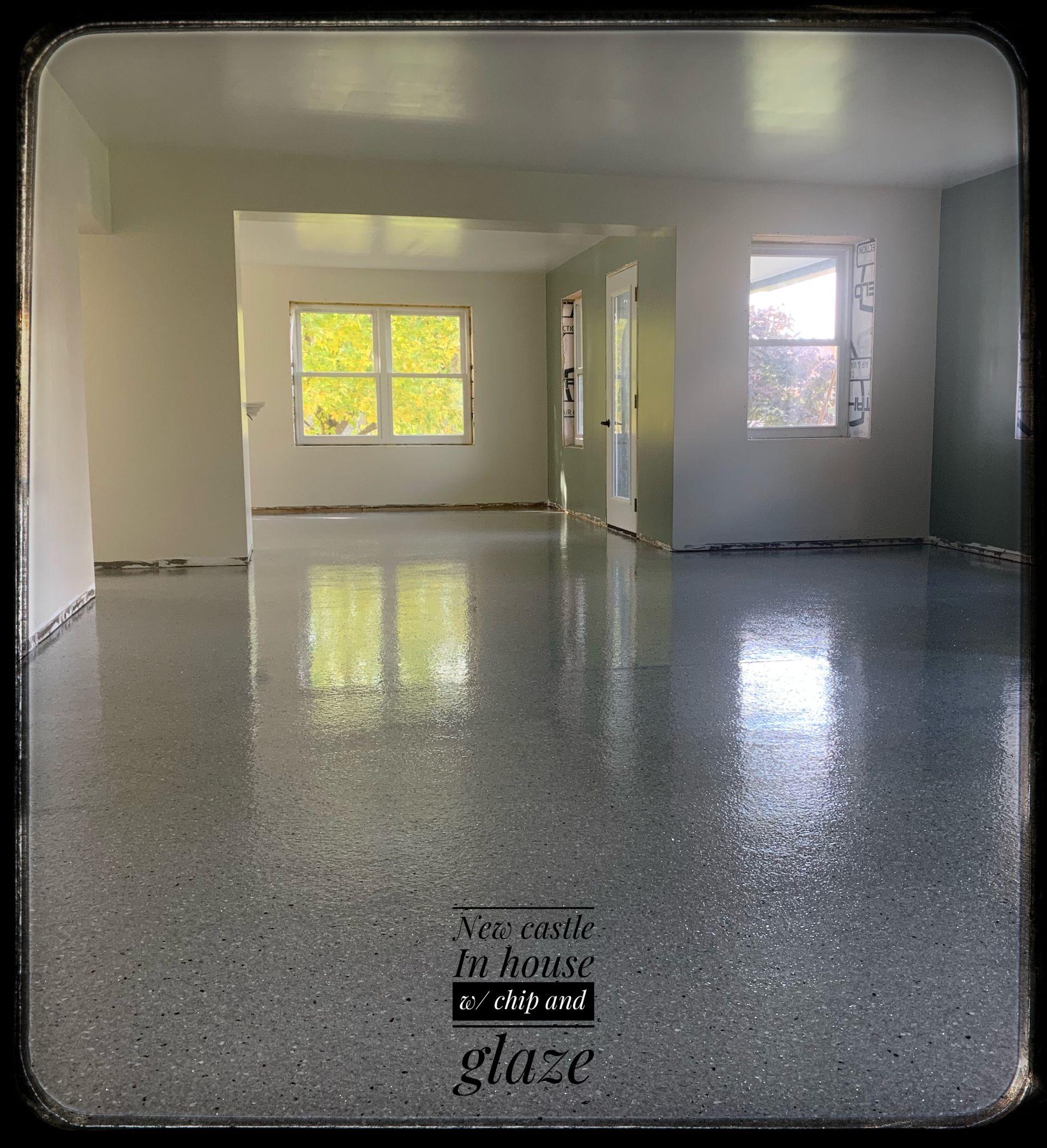 Empty modern room with glossy gray floor, white walls, and two sunlit windows.