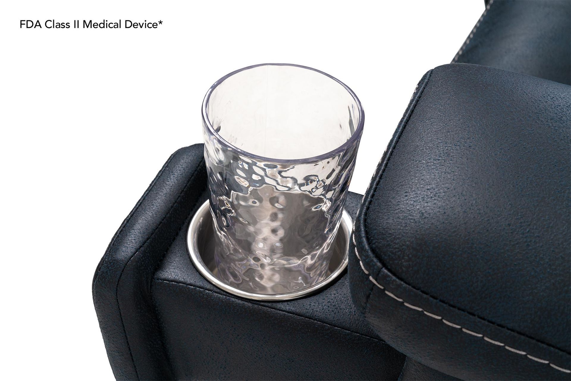 Clear glass in a silver cup holder on a black leather chair arm.