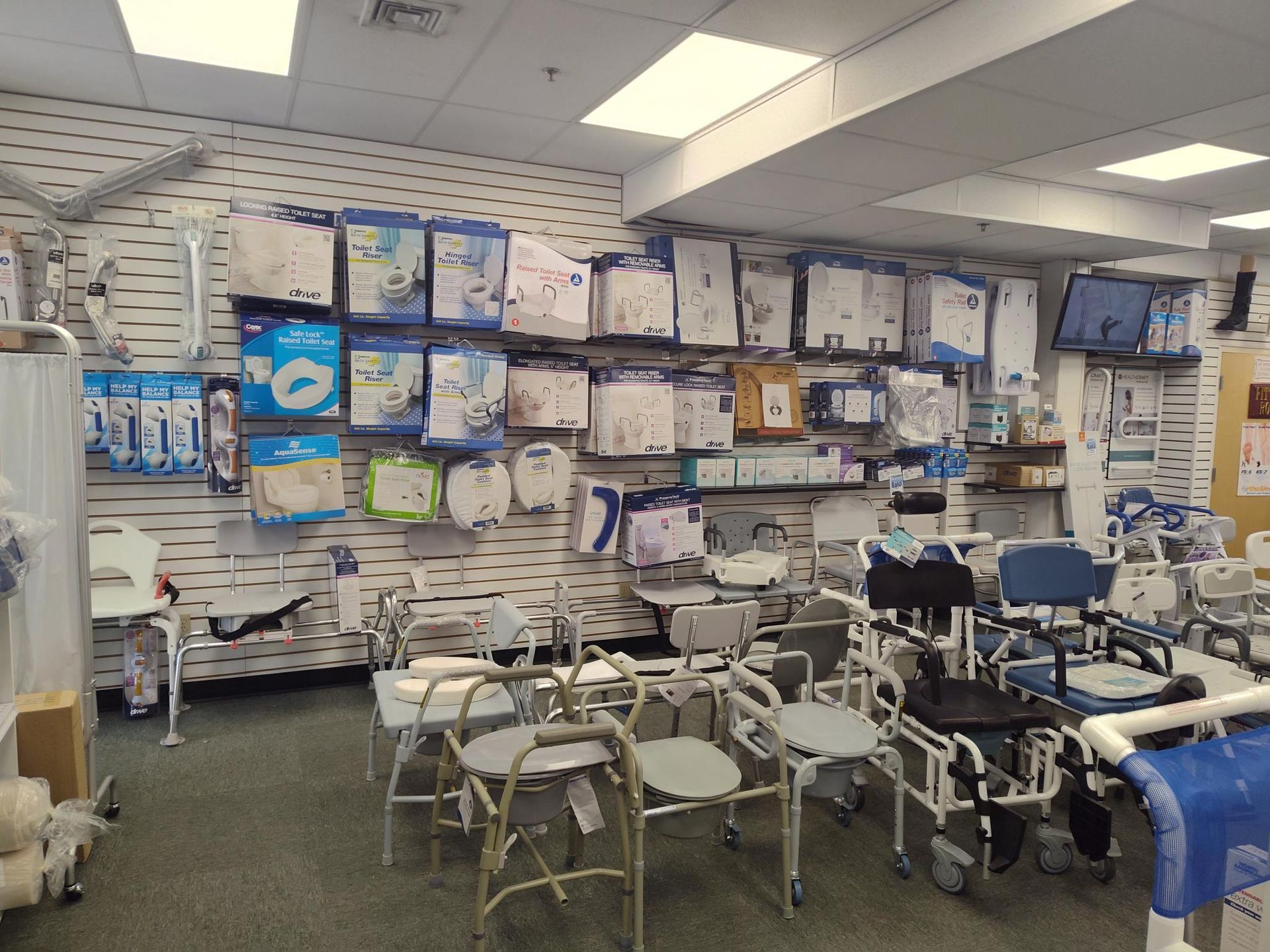 Medical equipment store: display of various mobility aids like chairs and walkers; hygiene products on wall shelves.