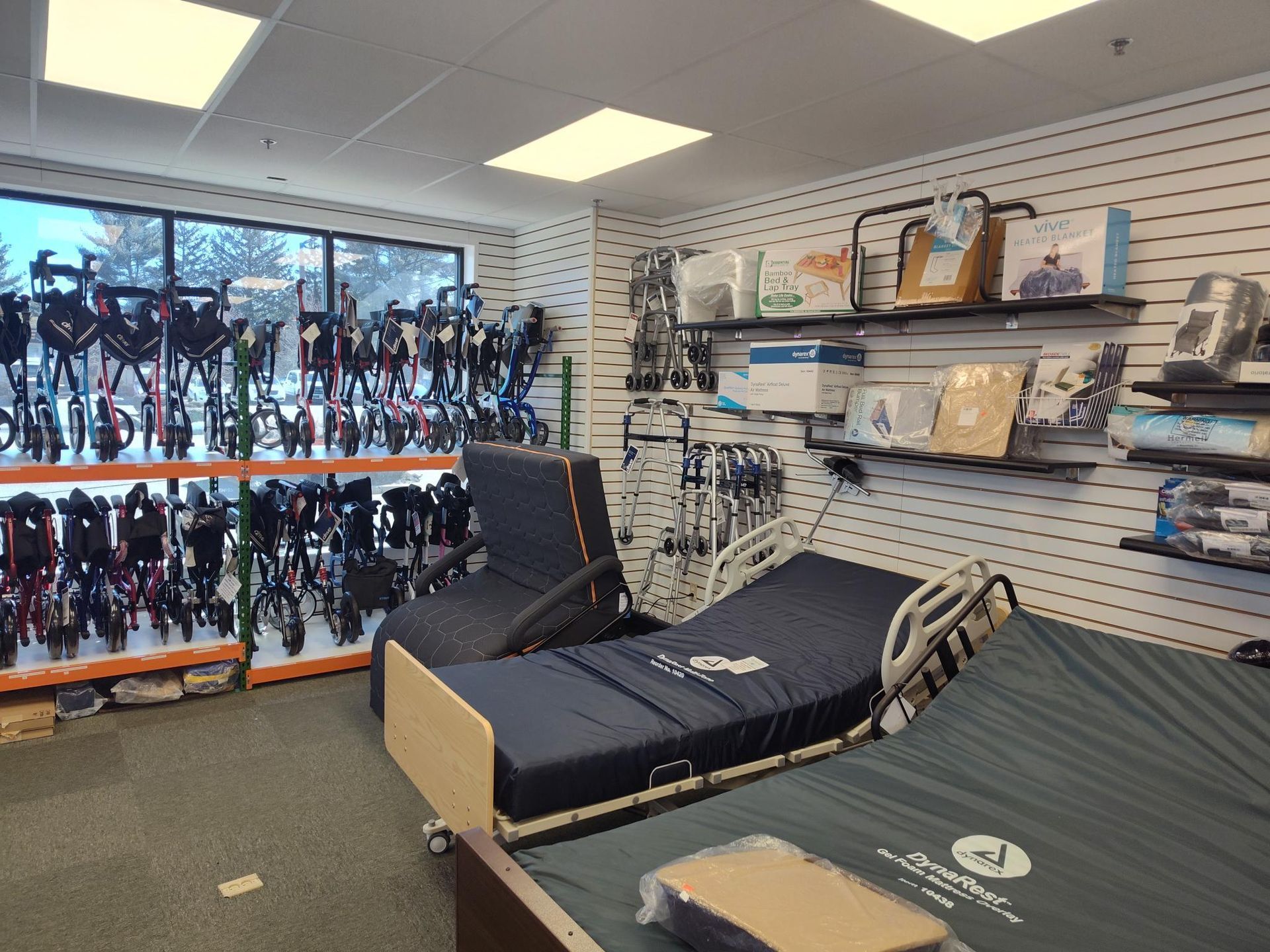 A medical supply store interior with adjustable beds, equipment displays, and a window overlooking a snowy landscape.