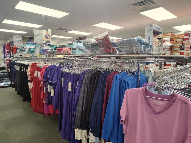 Clothing store interior with racks of colorful apparel and shelves of boxes.