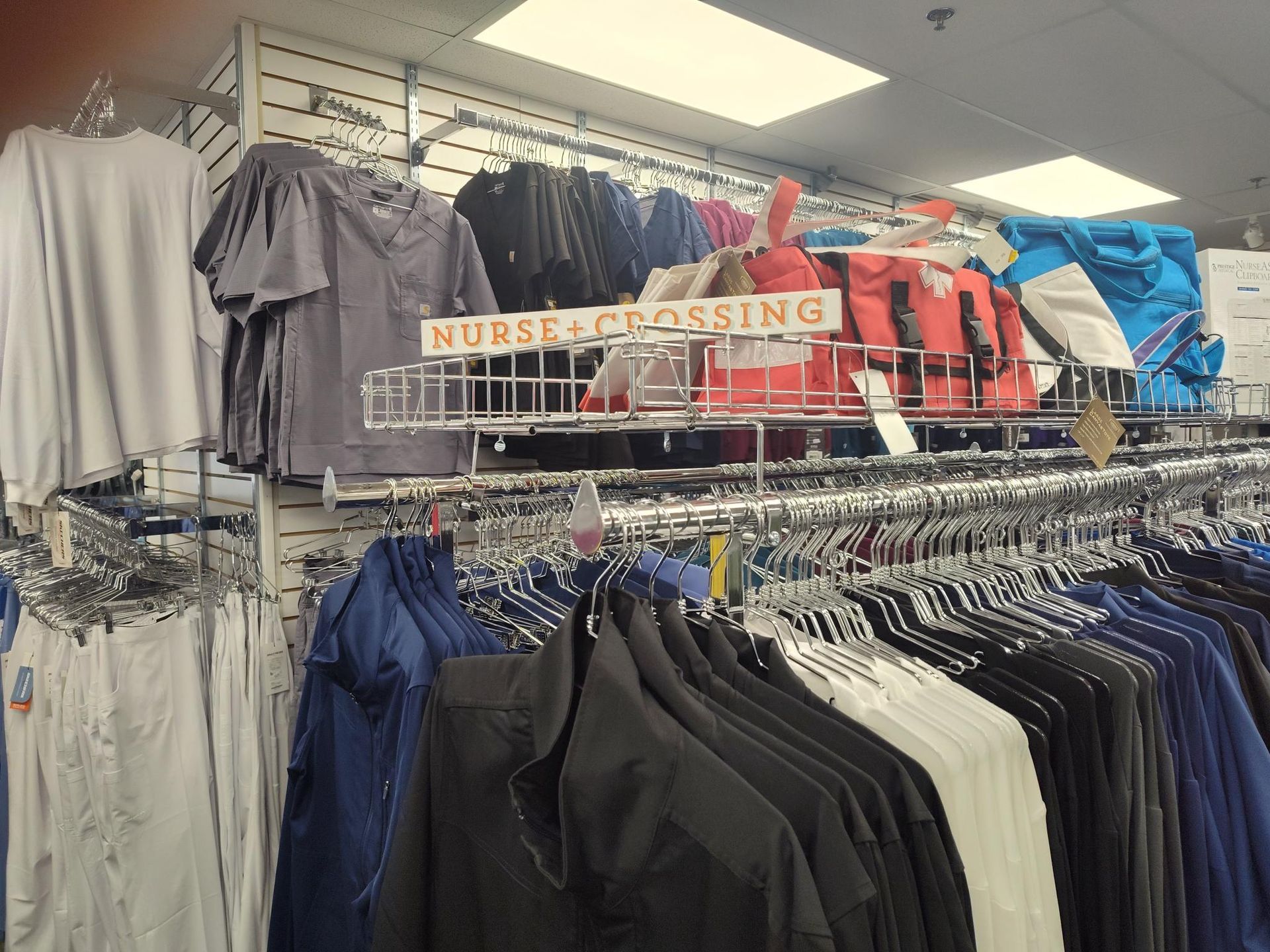 Clothing store display: racks of shirts and jackets, with a 