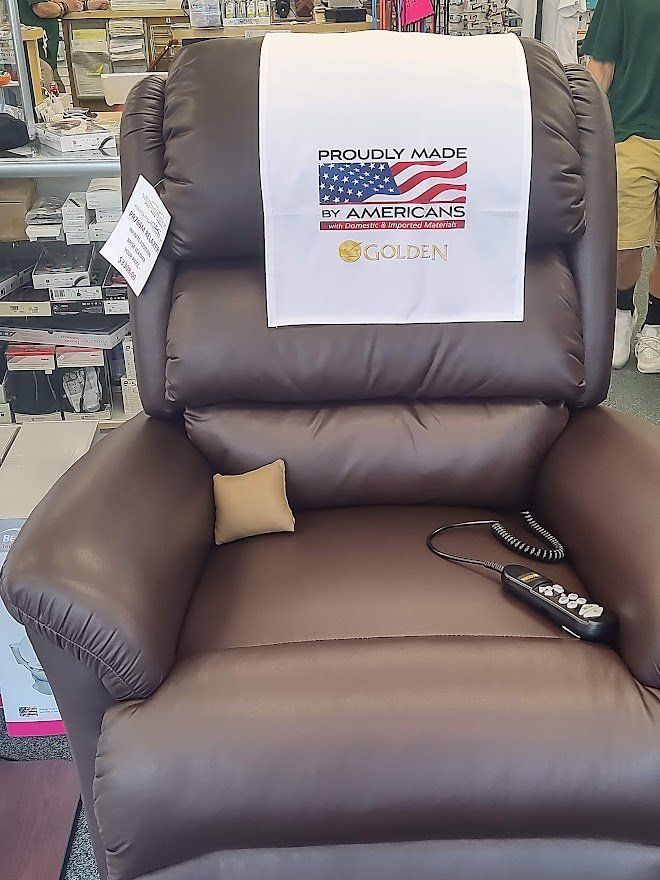 Brown recliner with "American Made" sign, remote control, and a small beige pillow.
