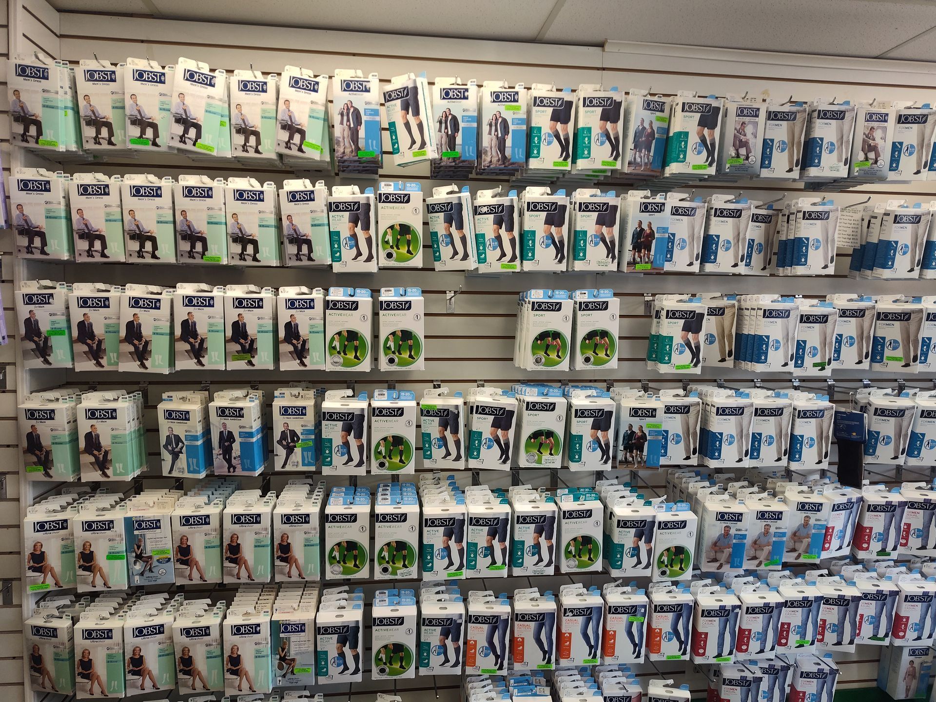 Wall display stocked with various knee and leg braces in packaging.