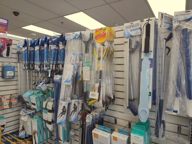 Display of packaged pool cleaning equipment in a store, including nets, brushes, and telescoping poles.