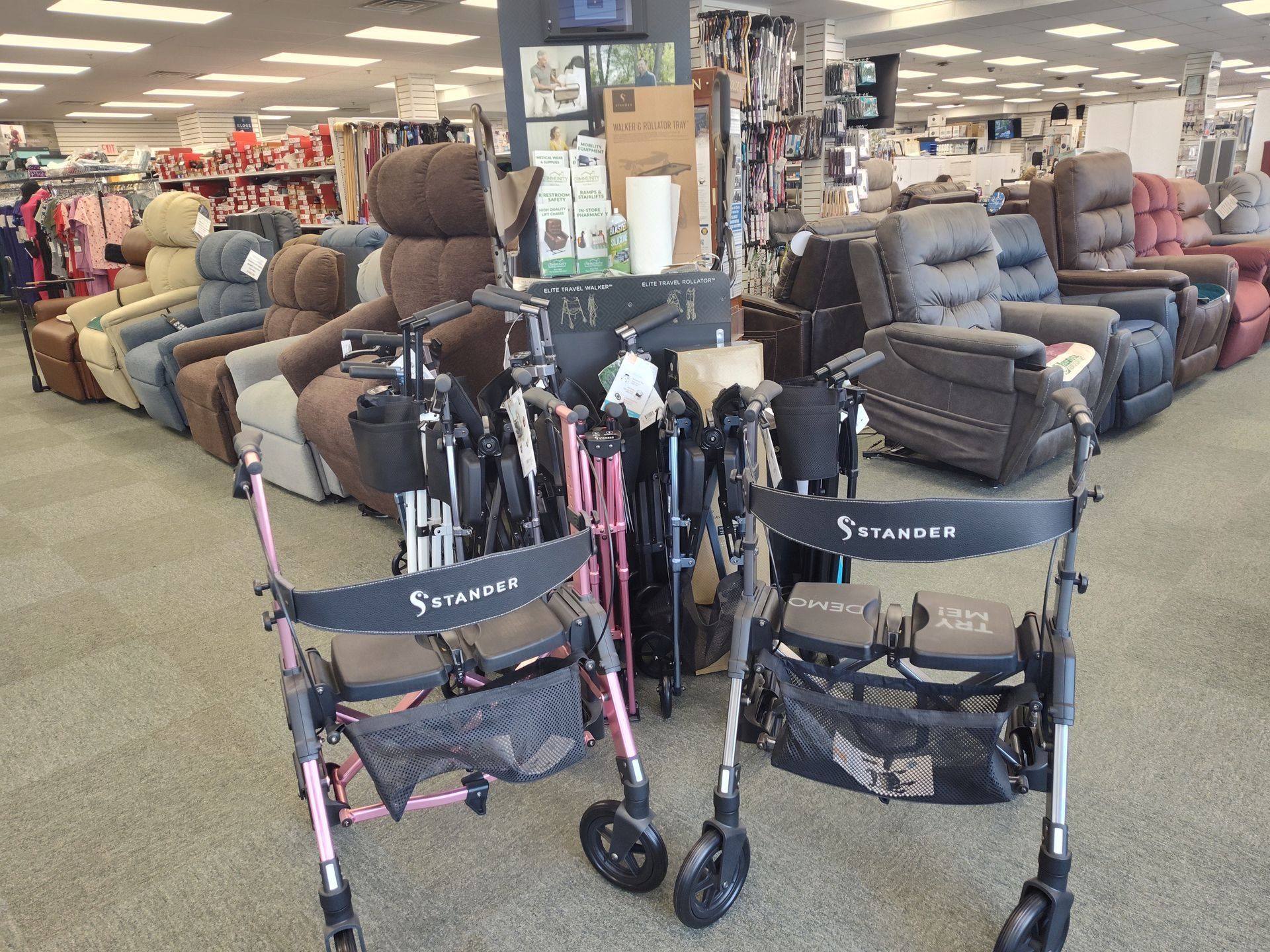 Pink and black walkers in a store aisle with lift chairs in the background.