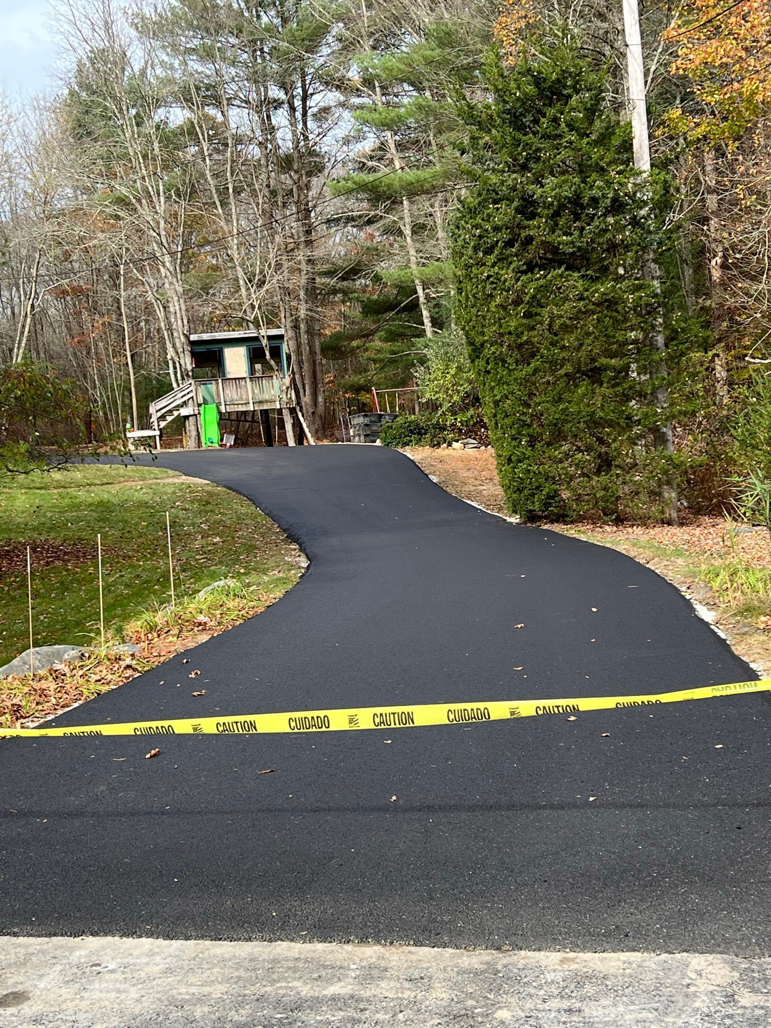 Young child wearing a neon jacket sits in the driver's seat of a vehicle, smiling.