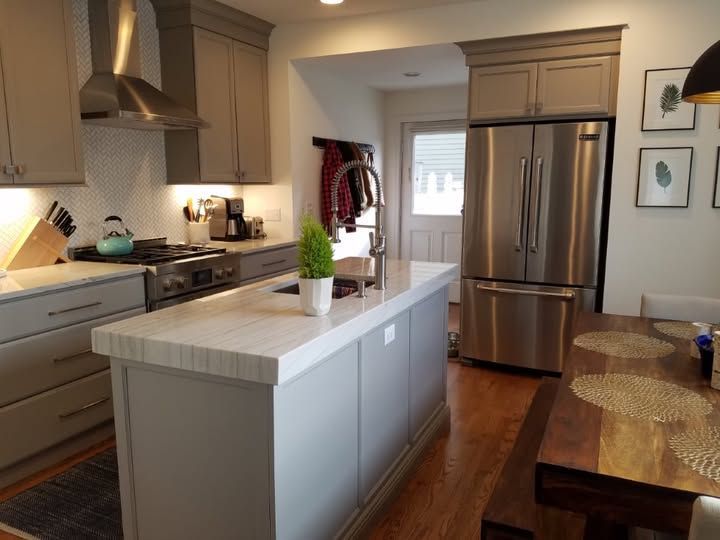 a kitchen with a large island and a stainless steel refrigerator