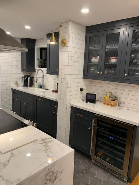 a kitchen with gray cabinets and white countertops
