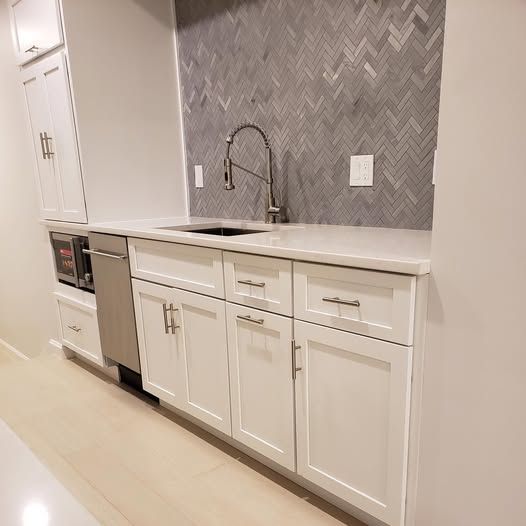 a kitchen with white cabinets, a sink, and a stainless steel dishwasher