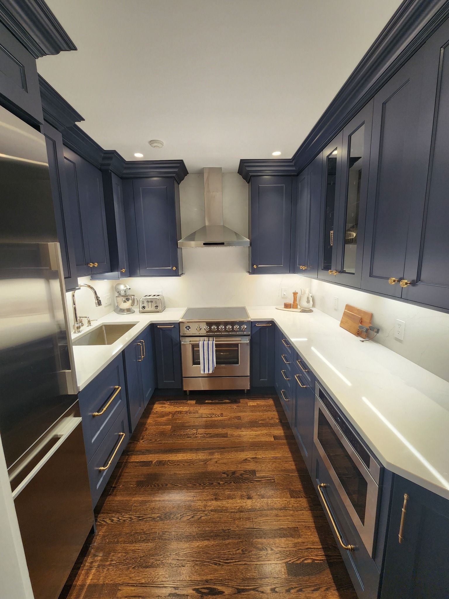 a kitchen with blue cabinets and stainless steel appliances
