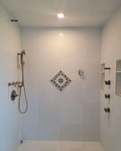 a bathroom with a walk-in shower and a diamond design on the wall
