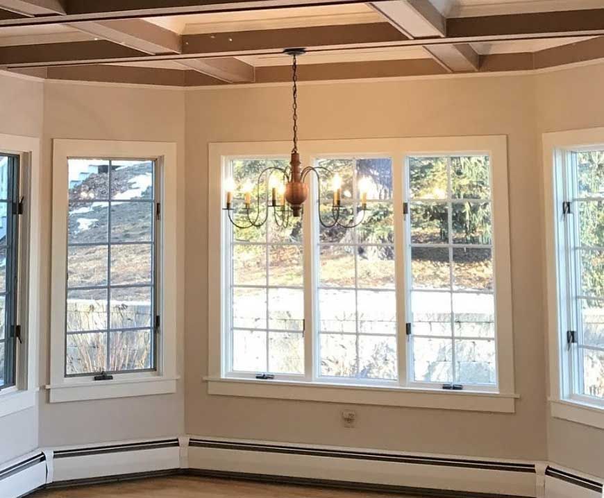 a room with a lot of windows and a chandelier hanging from the ceiling