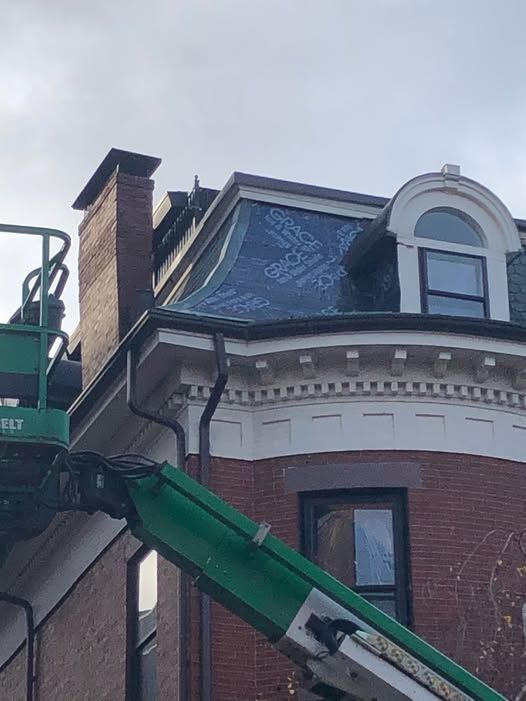 a green crane next to a brick building