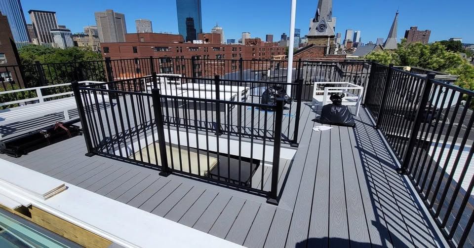 a rooftop deck with a fence and a view of the city