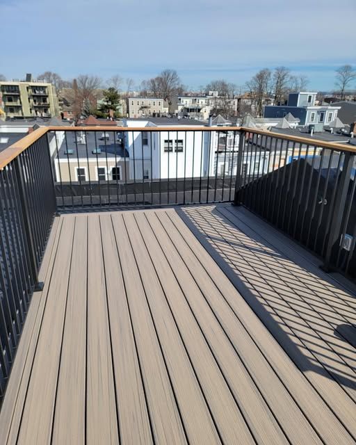 a deck with a railing and a view of a city