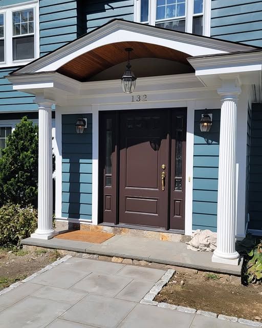 a blue house with a porch and a brown door