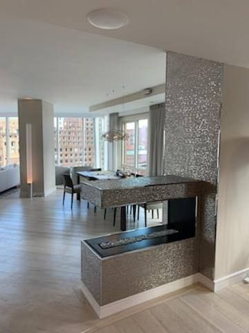 a living room with a fireplace and a dining room in the background