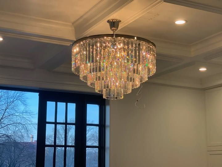 a large chandelier is hanging from the ceiling in a room next to a window