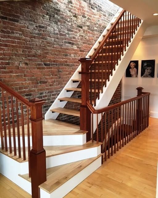 a wooden staircase with a brick wall behind it