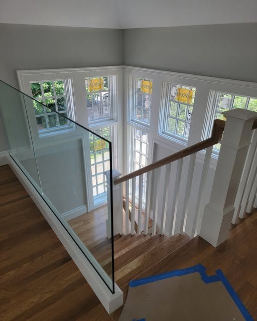 a staircase with a glass railing and lots of windows