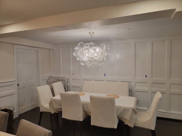 a dining room with a table, chairs, and a chandelier