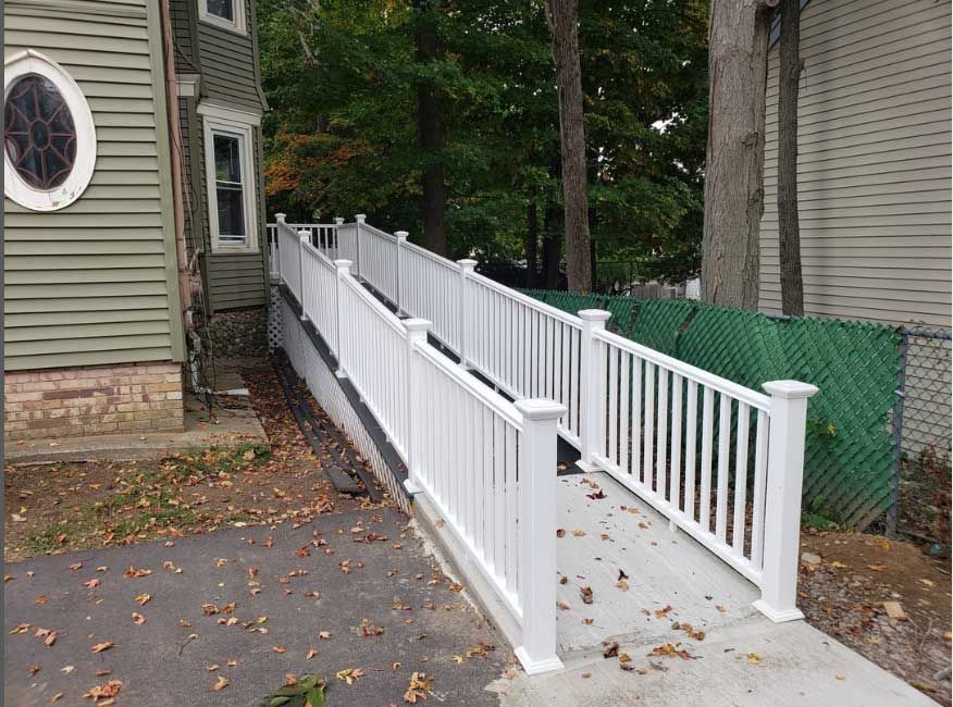 a ramp with a white railing leading to a house