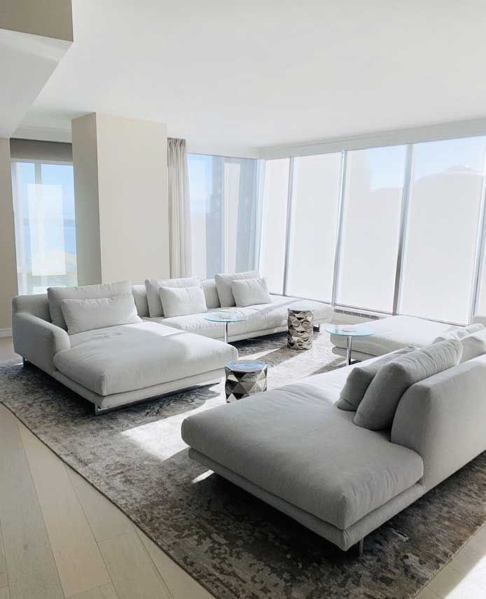 a living room filled with white furniture and a rug