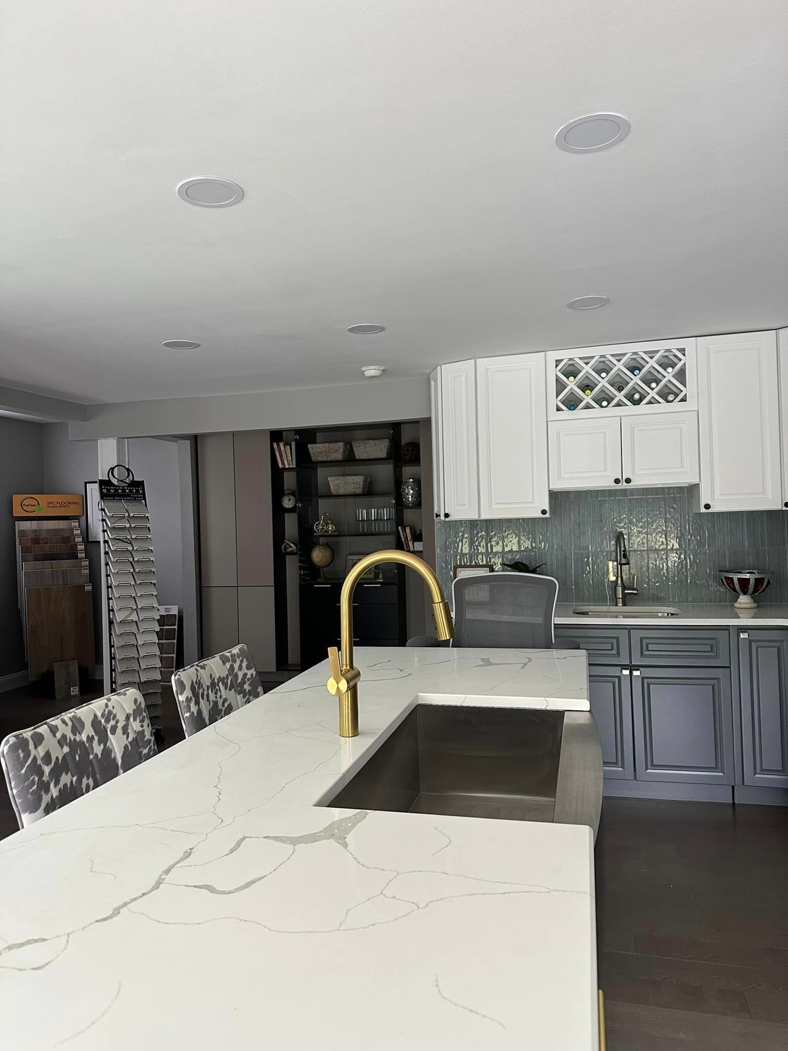 A kitchen with white cabinets, a sink and a faucet.