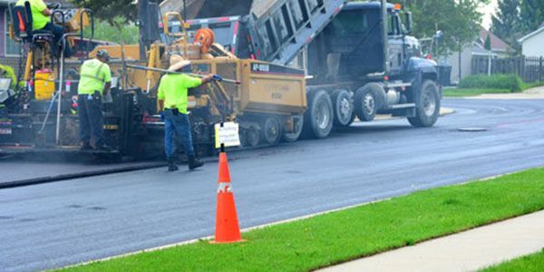 A group of construction workers are working on a road.