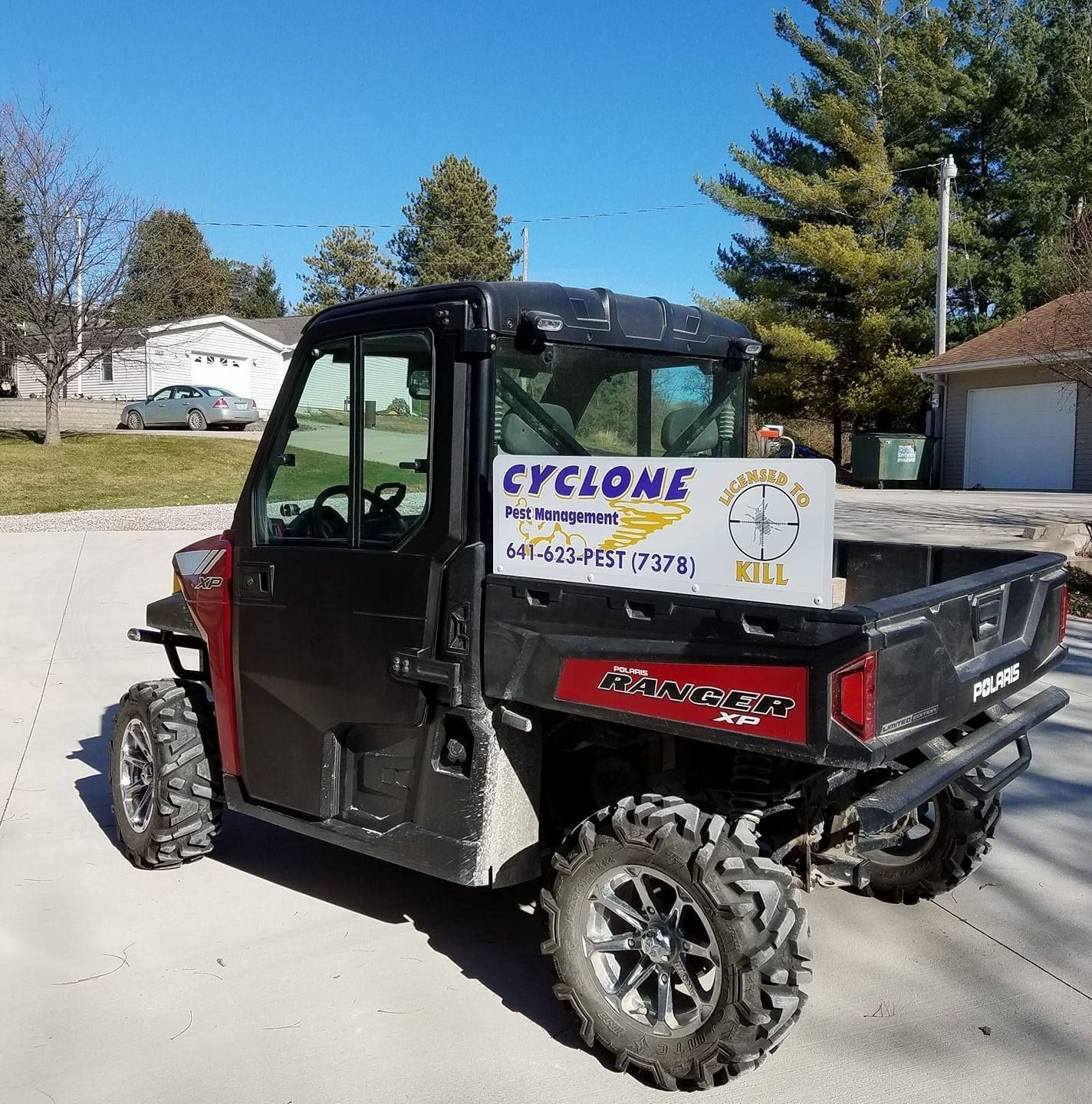 A polaris utility vehicle with a sign on the back that says cyclone.