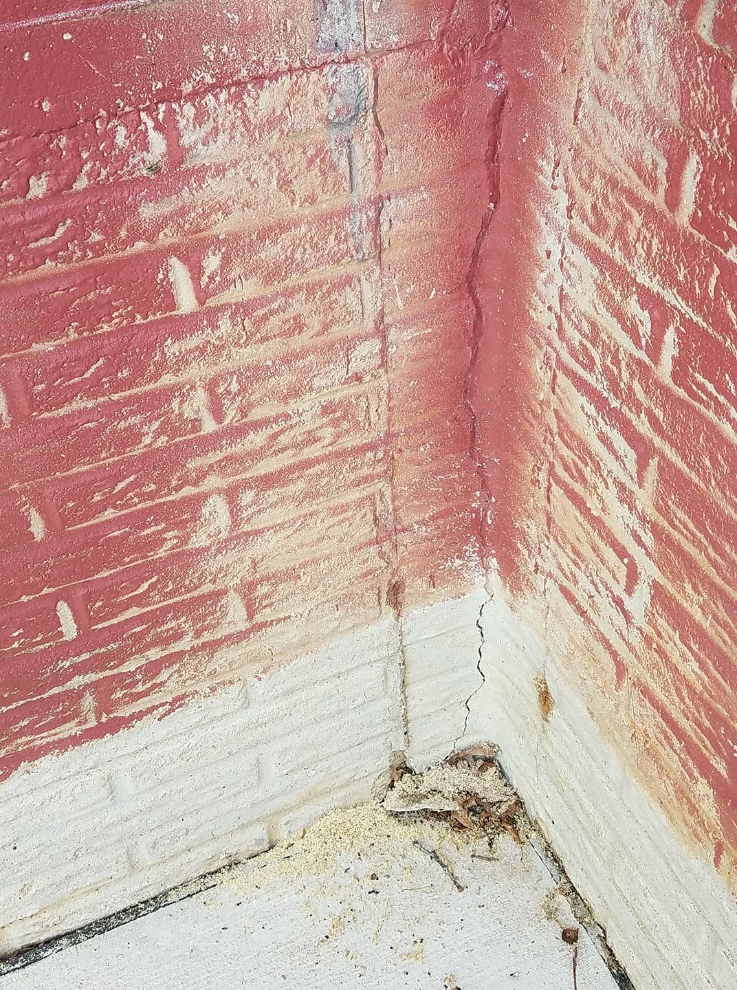 A corner of a room with a brick wall and a white floor.