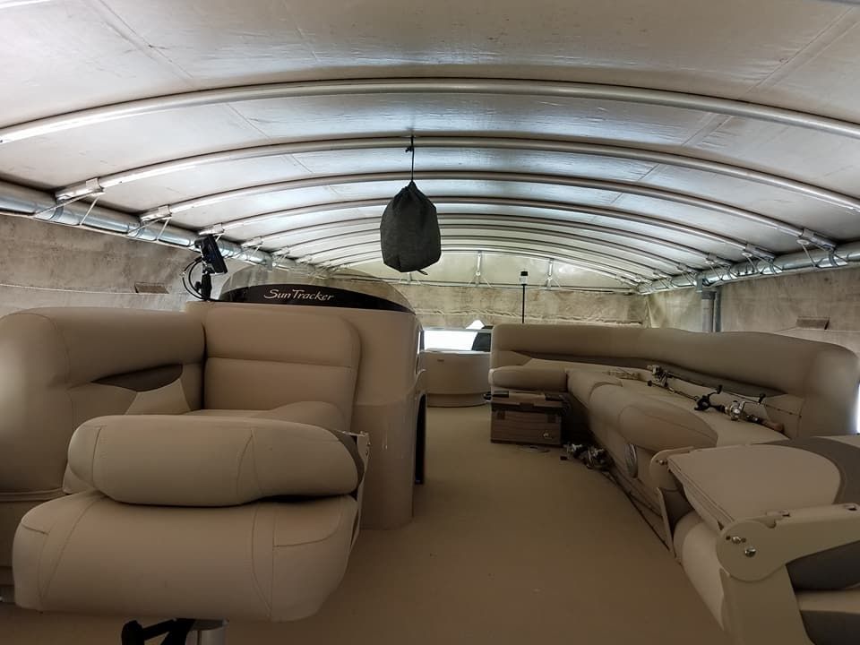 The inside of a pontoon boat with chairs and tables.