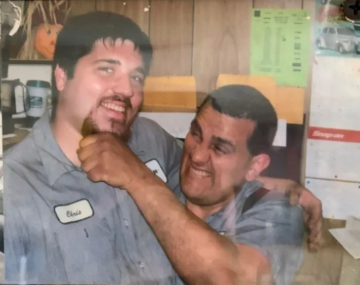 Two men are playfully interacting. One man, 