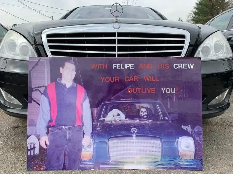 A black Mercedes-Benz with a sign that reads 