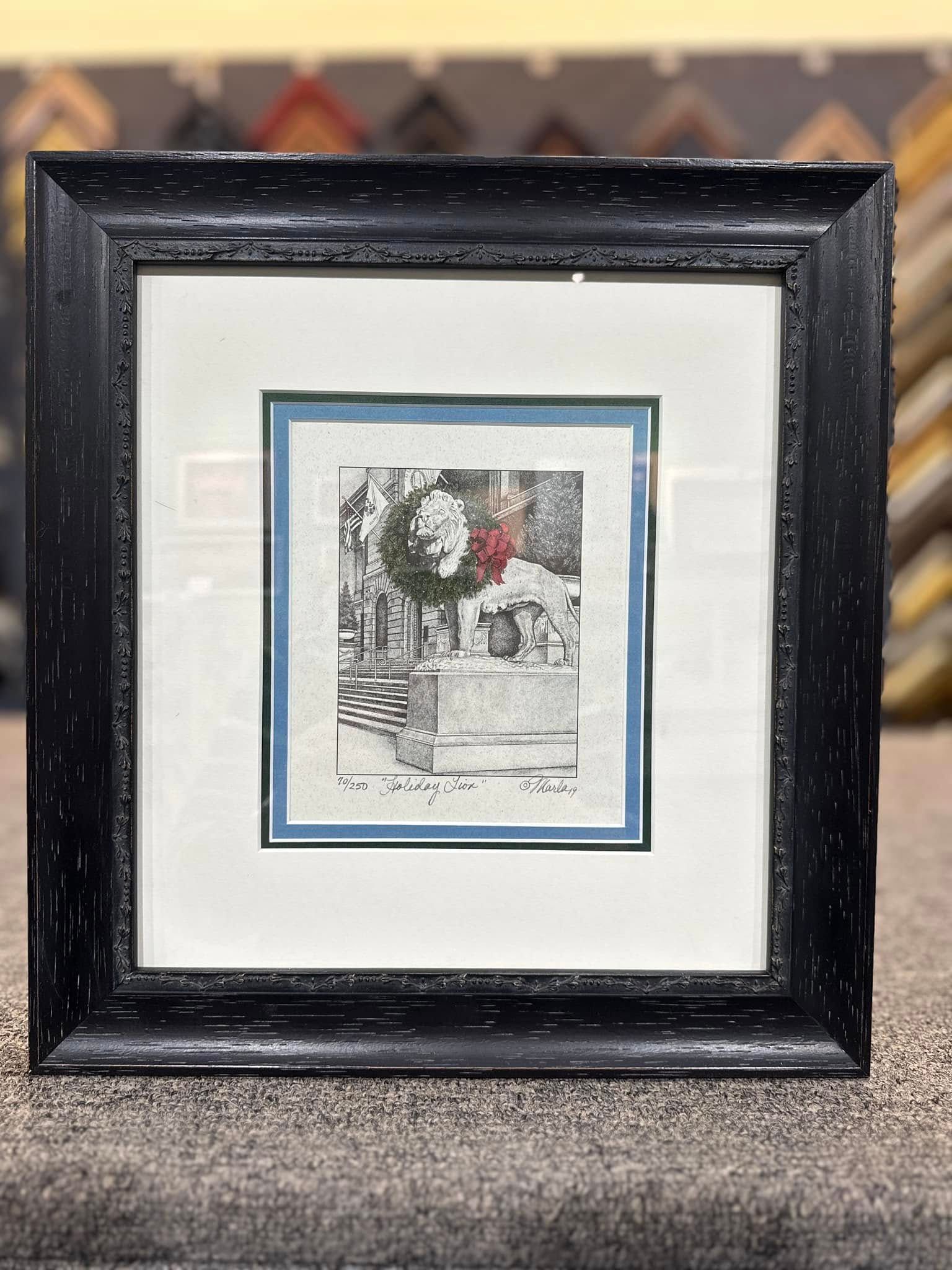 Framed artwork; black frame, white and blue mats around a black and white image of a building.