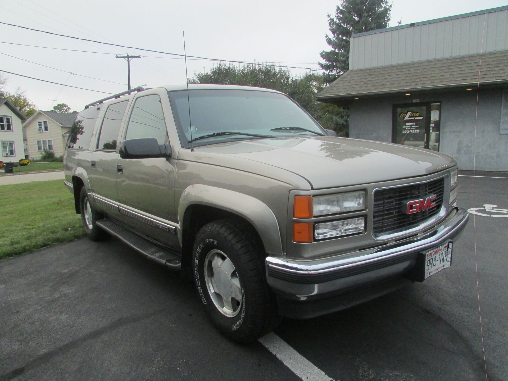 Tan GMC Yukon SUV parked on asphalt.
