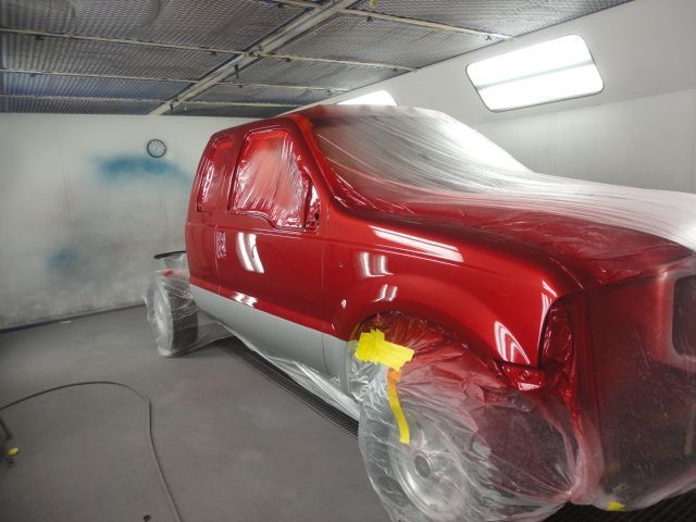 red pick-up truck during paint job