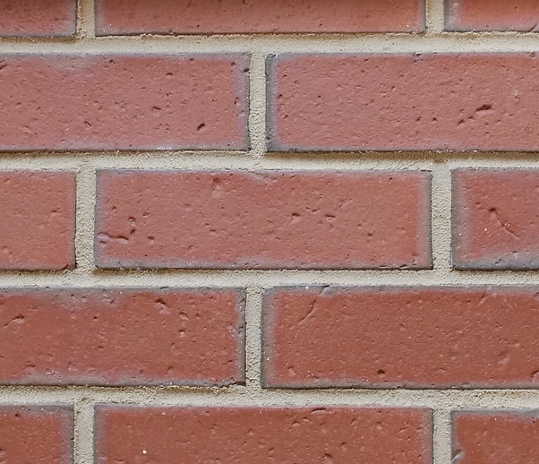 Close-up of a red brick wall with light gray mortar lines