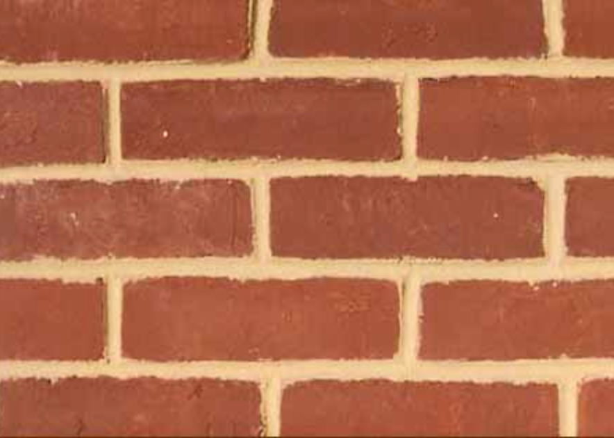 Close-up of a red brick wall with light gray mortar lines
